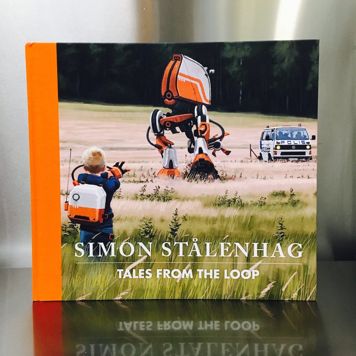 Tales from the Loop – An eerie account of a physics research facility gone awry

Tales from the Loop

by Simon Stålenhag

Design Studio Press

2015, 128 pages, 10.1 x 11.2 x 0.7 inches

$33 
Buy a copy on Amazon

Unfamiliar with sci-fi artist Simon Stålenhag, I was sucked into his eerie dystopian history the instant I cracked open Tales from the Loop. His hyper-real digital paintings depict beautiful Swedish country towns where snow falls in the winter and children play in nature. But each of these pastoral scenes are jarring, with intrusive machines, robots, discarded equipment, and power lines upstaging the otherwise serene landscape.

The book explains that these paintings were inspired by childhood memories of the author, who grew up in a large area of Sweden that housed an underground experimental physics research facility known as The Loop. Alongside each painting is a short essay from the author’s memory. For instance, the three cooling towers in the photo above were built to release heat from the core of the Loop. The towers, which “started like a deep vibration in the ground that slowly rose to three horn-like blasts,” remind Stålenhag of a miserable day he had with a boy named Ossian, who had lured him to his house to play Crash Test Dummies, but ended up bullying him with the help of his brother until Stålenhag went home in tears.

Each painting is accompanied by one of these short yet captivating stories, and their detailed, relatable quality had me going. As I read about Stålenhag and his best friend Olof sneaking off with a boat on a nice summer day to a disturbing machine-littered swimming pond, I kept thinking, “I must go online and research the Loop! How could I have never heard about this creepy place?” Then I quickly got to the robots. Huge dinosaur and prehistoric animal robots. And towering two and four-legged machine robots, crushing everything in their paths. Suddenly, with a “Wait a minute!” moment, I knew I’d been had. The same way I was duped when I saw The Blair Witch Project and thought, at first, that it was a real documentary. But my gullibility doesn’t bother me – what a fun treat it is to be swept into a horrific alternative reality, only to find out it’s masterful fiction.  

Stalenhag’s Tales from the Loop is striking, creepy, and captivating. It’s both an intriguing coffee table book and an engaging novel of sorts. And for me, it was an exciting ride.

– Carla Sinclair

February 26, 2016