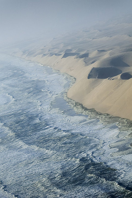 The waves of the Atlantic breaking against the sand cliffs of Namib desert, Namibia